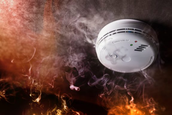 Smoke detector and fire alarm in action background with copy space