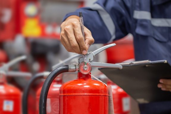 Engineer are checking and inspection a fire extinguishers tank in the fire control room for safety training and fire prevention.